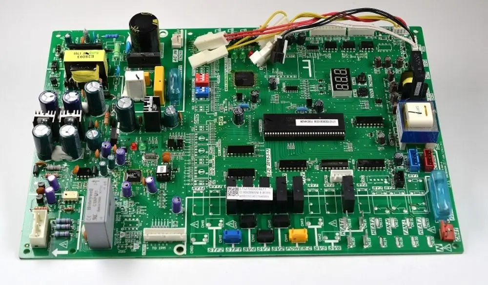 Grüne Steuerplatine von Remko mit verschiedenen elektronischen Bauteilen. Enthält Anschlüsse, ein Display und mehrere Kondensatoren sowie Widerstände.
