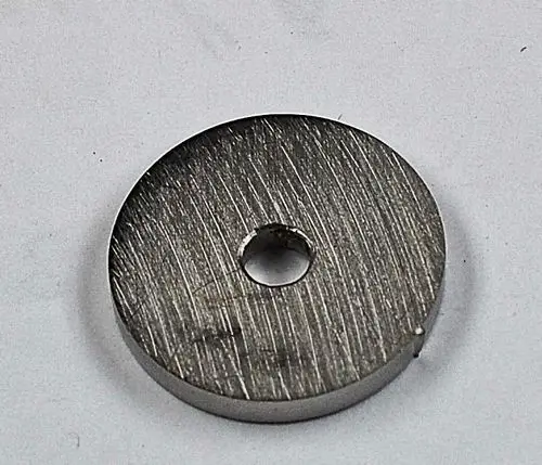 Metallene runde Scheibe mit einem zentralen Loch, vermutlich ein Teil von Gasmembranen oder ähnlichen Anwendungen. Marke Remko sichtbar.