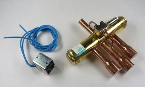 Vierrohr-Umkehrventil der Marke Remko mit Kupferrohren und elektrischen Anschlüssen. Das Gerät ist für spezifische Heiz- oder Kühlsysteme konzipiert.