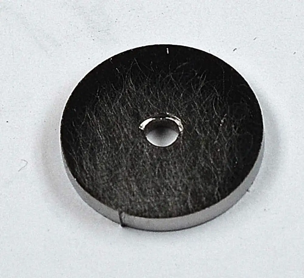 Schwarze Gasmembran mit zentralem Loch, hergestellt von Remko. Die Oberfläche zeigt feine Strukturen. Ideal für den Einsatz in Gasgeräten.