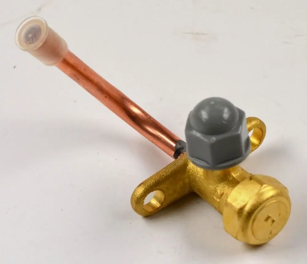 Remko Absperrventil an einer Einspritzleitung, bestehend aus einem goldfarbenen Metallkörper mit einer Kupferleitung und einem grauen Kunststoffknopf.