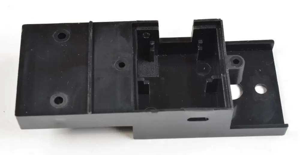 Schwarze Halterung mit Aussparungen und Löchern, möglicherweise für einen Sensor. Produkte von Remko sind oft für Lüftungs- und Klimaanlagen konzipiert.