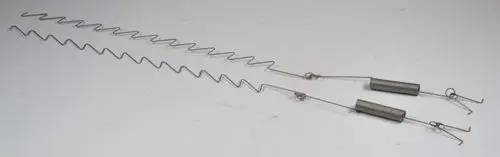 Federmechanismen aus Metall, verwendet in Heizsystemen, produziert von Remko, mit gewellten und spiralförmigen Elementen.