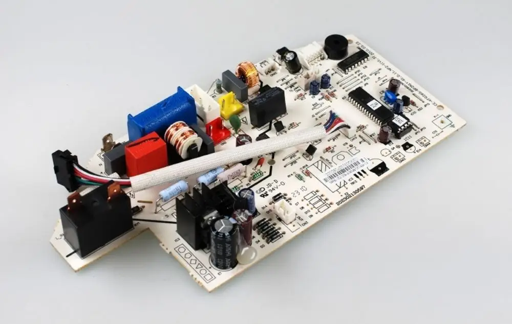 Steuerplatine von Remko, ausgestattet mit mehreren elektronischen Komponenten, wie Relais, Kondensatoren und Widerständen auf einer bedruckten Leiterplatte.
