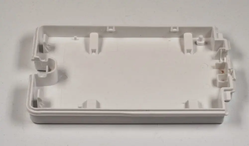 Kunststoffabdeckung von Remko, die eine Platine schützt. Sie hat eine flache Form und ist in weißer Farbe gehalten. Die Innenseite weist Befestigungselemente auf.