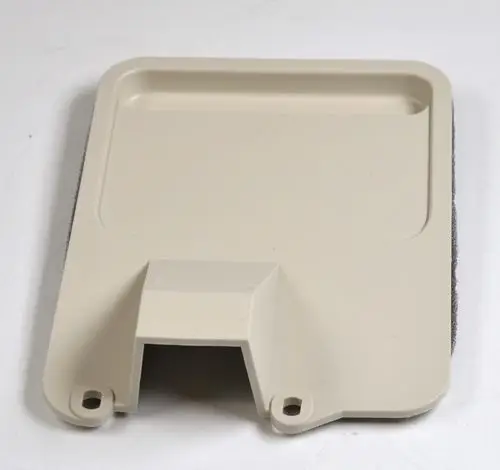 Kunststoffabdeckung in hellem Beige mit einer glatten Oberfläche und Aussparung, wahrscheinlich für einen Klemmblock von Remko. Rückseite ist mit einem grauen Material versehen.