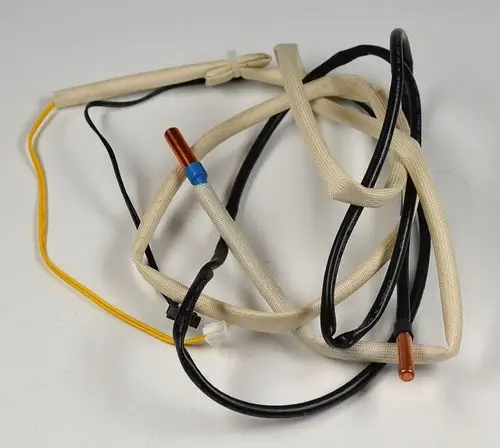 Temperatursensor mit mehreren Kabeln, darunter ein Kupferteil und eine blaue Markierung. Verwendung in Geräten der Marke Remko zur Messung von Temperaturen.