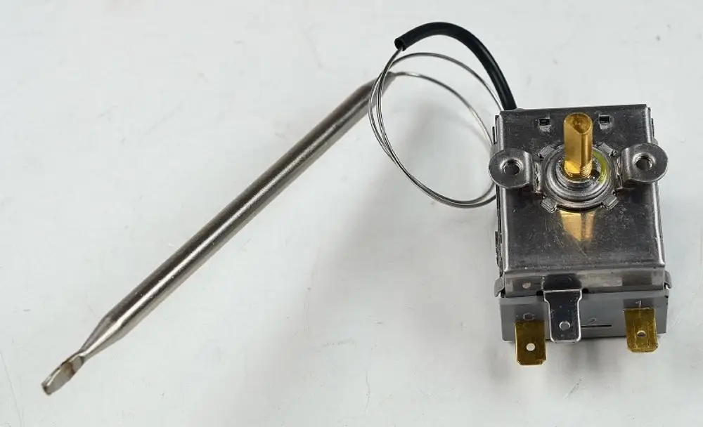 Remko-Thermostat mit einem Gehäuse, zwei Anschlussklemmen, einem vernickelten Stift und einer Temperaturfühler-Sonde.