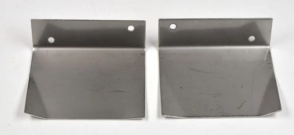 Zwei glänzende Metallbleche mit abgerundeten Ecken und jeweils zwei Bohrungen, offensichtlich Zubehörteile der Marke Remko zur Kondensatführung.