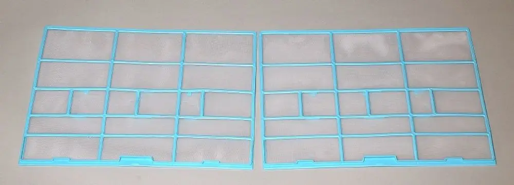 Zwei blaue Luftfilter mit quadratischen Maschen, produziert von Remko, auf einer grauen Fläche angeordnet. Die Filter sind in zwei gleich große Sektionen unterteilt.