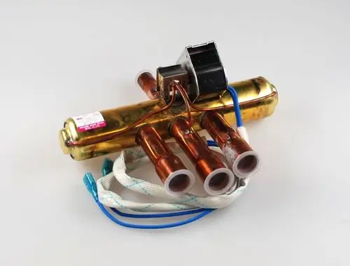 Remko Umkehrventil in goldener und kupferner Ausführung mit mehreren Anschlüssen und elektrischen Leitungen, auf hellgrauem Hintergrund.