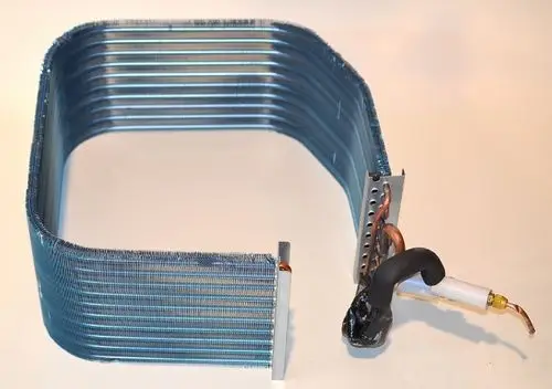 Verdampfer von Remko, mit mehreren gewickelten Metallrohren in blauer Beschichtung. Anschlüsse sind seitlich angebracht.