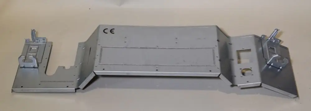 Verkleidungsteil in Metalloberfläche mit verschiedenen Halterungen. Produkt von Remko, geeignet für spezifische Anwendungen im technischen Bereich.
