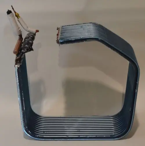 Verdampfer von Remko, in geschwungener Form, mit einem Abschnitt, der eine unregelmäßige Oberfläche aufweist und mit verschiedenen Materialien ergänzt ist.
