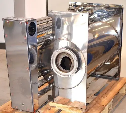 Edelstahl-Brennkammer von Remko, bestehend aus glänzenden Metalloberflächen mit mehreren Anschlüssen, auf einem Holzpalett gestapelt.
