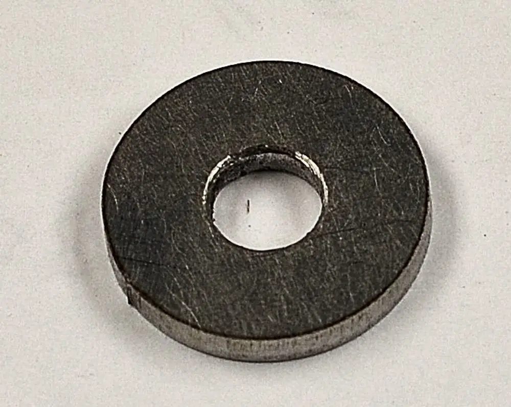 Metallische Scheibe mit zentralem Loch, auf einer weißen Oberfläche liegend. Die Marke Remko ist auf der Oberseite sichtbar.