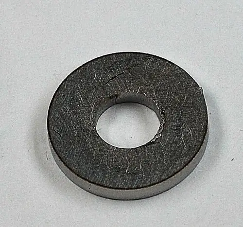 Graue, runde Metallscheibe mit innenliegendem Loch, auf weißem Hintergrund. Möglicherweise Teil eines größeren Systems von Remko.