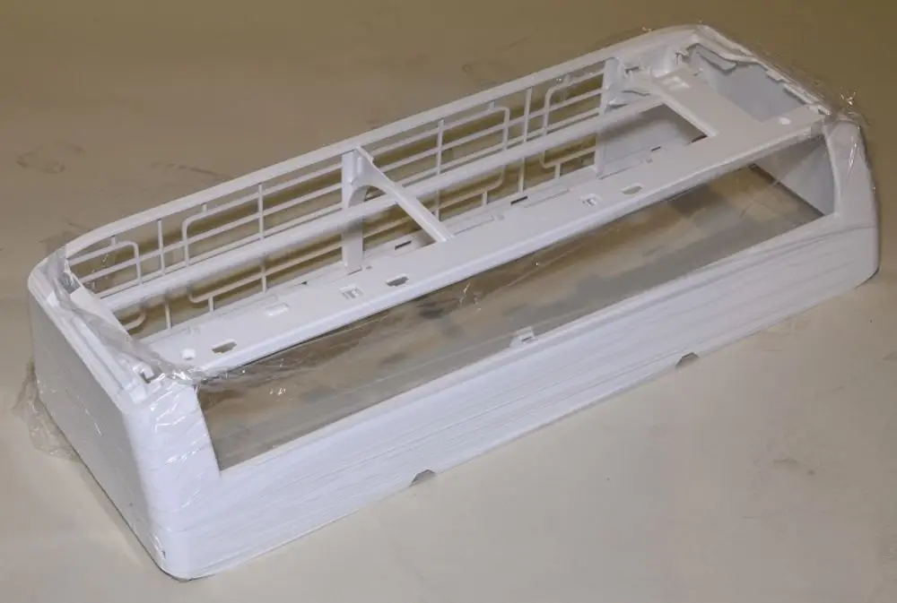 Weißes Gehäuse für Klimagerät, teilweise verpackt, mit technischen Öffnungen und Einschnitten, produziert von Remko.