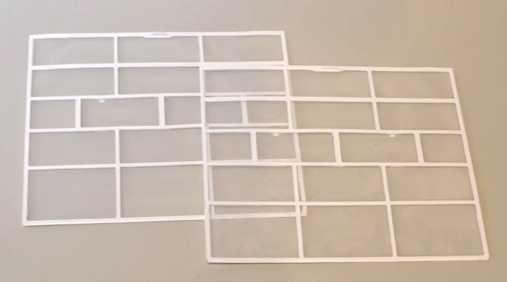 Zwei weiße Kunststoffrahmen mit rechteckigen Öffnungen, die als Luftfilter von Remko verwendet werden können. Sie liegen auf einem hellen Untergrund.