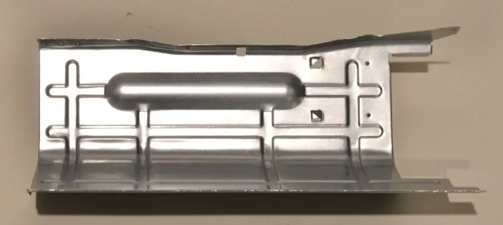 Trennblech aus Metall mit einer glatten, reflektierenden Oberfläche, das für Anwendungen von Remko verwendet werden kann. Die Form weist verschiedene Aussparungen und Verstärkungen auf.