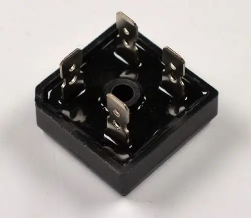 Gleichrichter mit quadratischer Grundform, vier Anschlussklemmen und einer zentralen Bohrung. Produkt von Remko, geeignet für DC-Anwendungen.