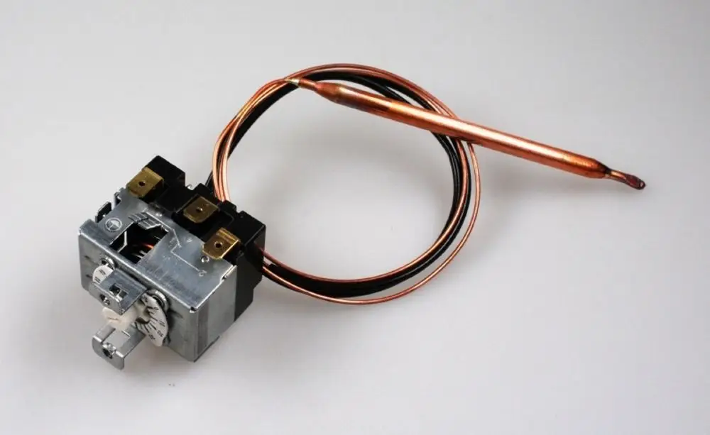 Nachlaufrelais von Remko mit zwei Anschlussklemmen und einem Temperatursensor aus Kupfer. Die Platine ist durch einen Metallkörper geschützt.