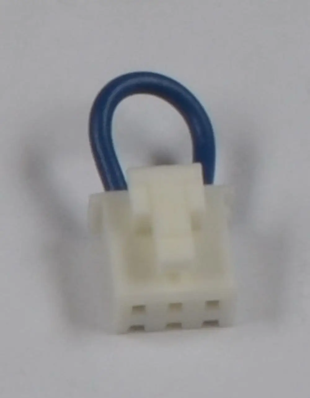 Weißer Brückenstecker von Remko mit einem blauen Kabel, bestehend aus einem mehrpoligen Anschluss.