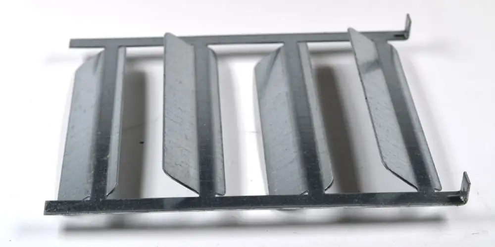 Metallisches Bauteil mit mehreren wellenförmigen Lamellen, das zur Rauchgasbremse von Geräten der Marke Remko eingesetzt wird. Bietet eine effiziente Luftführung.