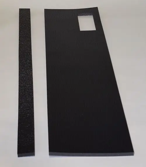 Schwarze Dämmplatten von Remko, eine größere rechteckige Platte mit einem rechteckigen Ausschnitt und eine schmale Leiste, auf einem neutralen Hintergrund.