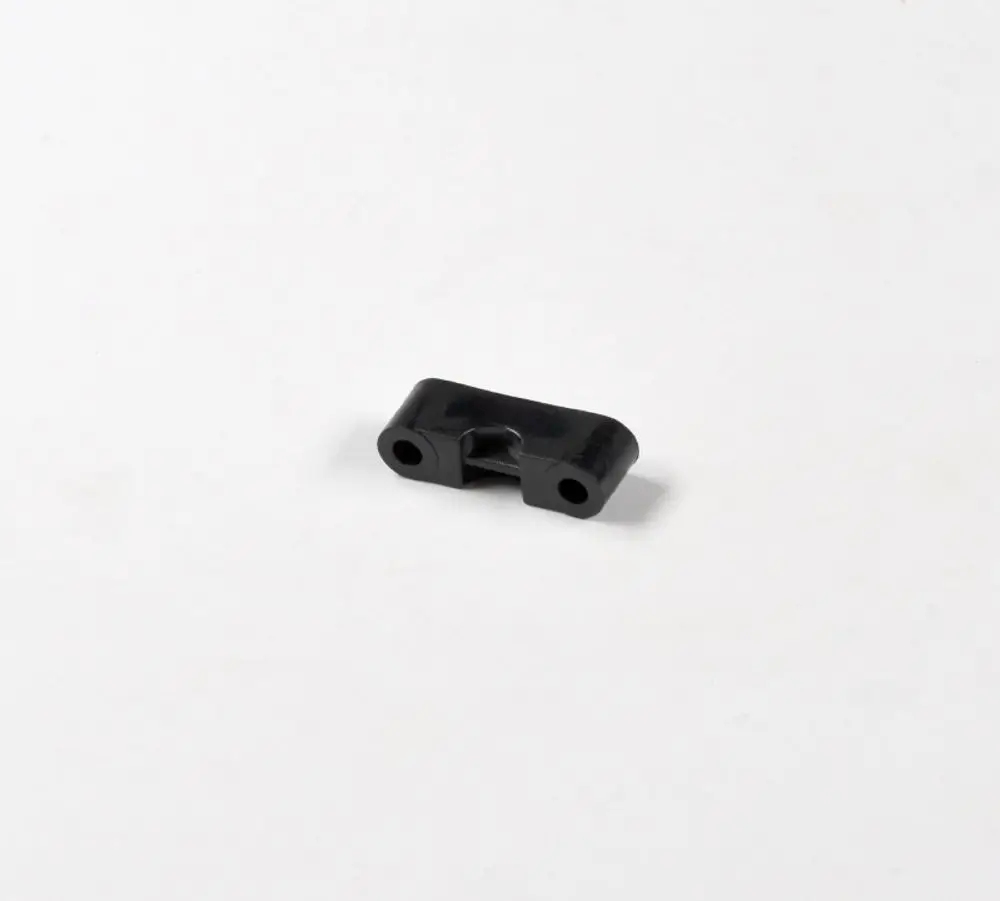 Schwarzes Kunststoffteil mit zwei Bohrungen in der Mitte, möglicherweise für eine Verbindung oder Befestigung. Produkt von Remko.
