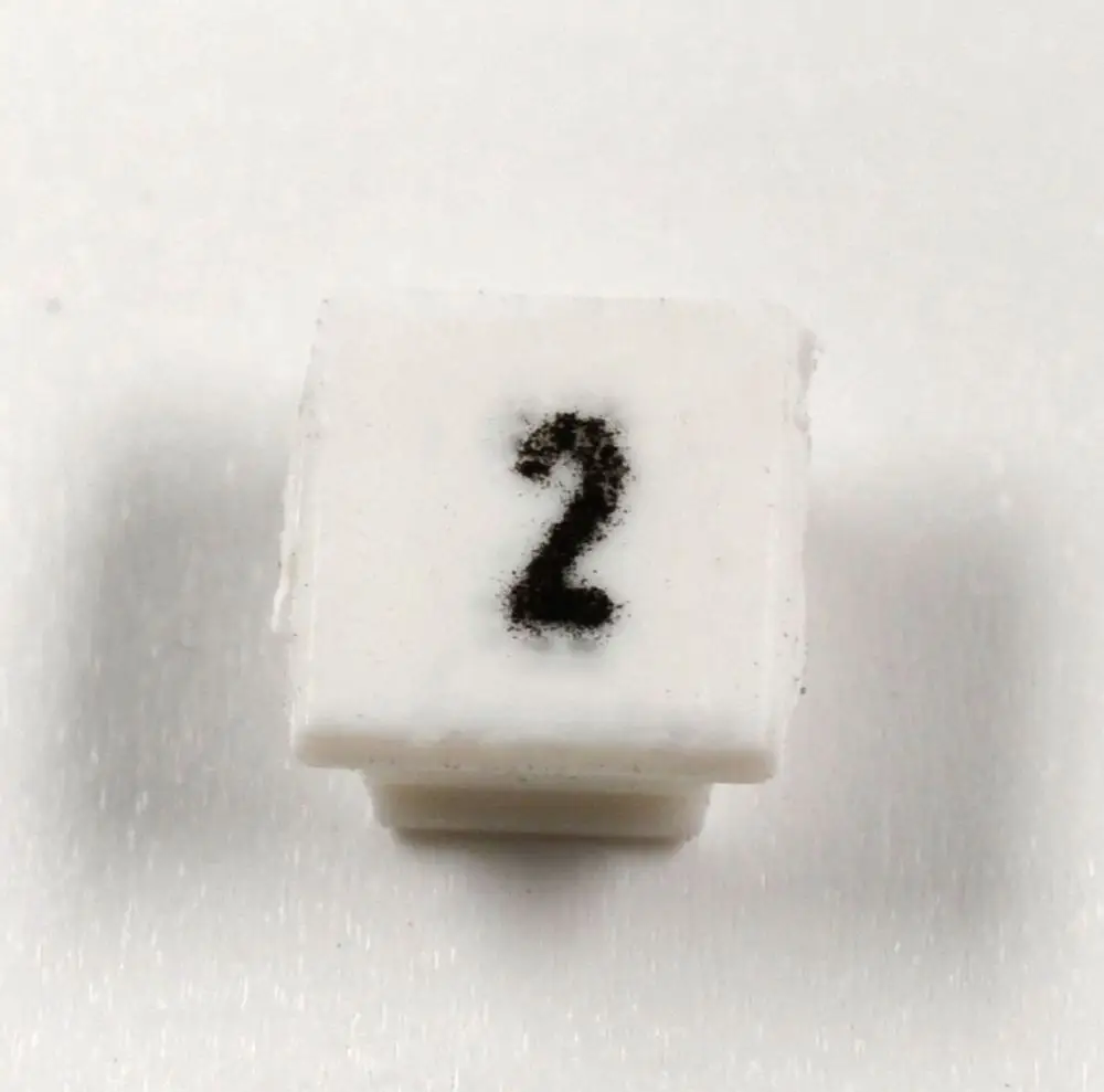 Weiße Klemmenmarkierung mit der Zahl 2 in schwarzer Schrift, geeignet für die Kennzeichnung von Leitungen oder Anschlüssen. Marke: Remko.