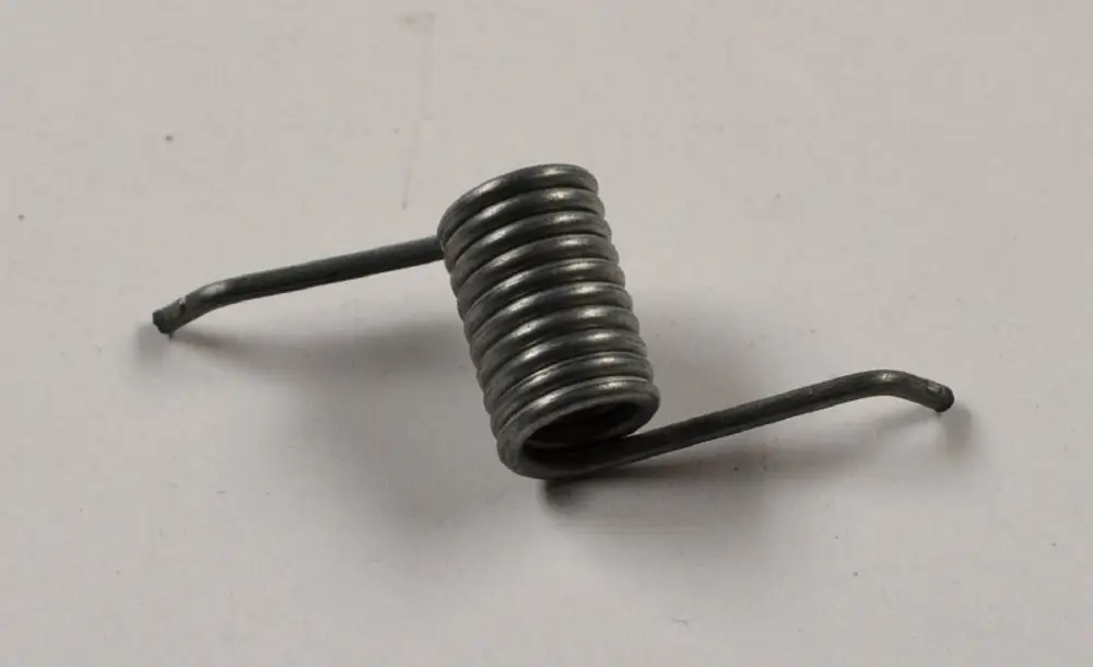 Metallfeder mit gewundenem Körper und zwei abstehenden Enden. Teil eines Luftklappenmechanismus, möglicherweise von der Marke Remko.
