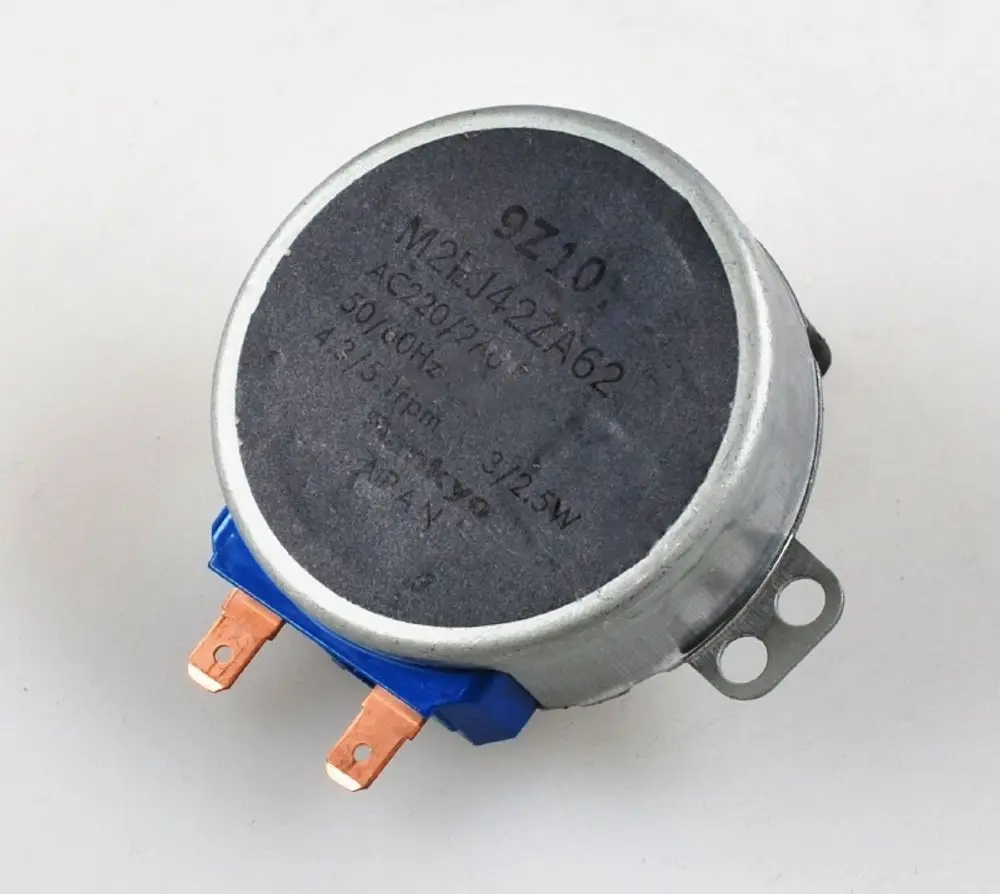 Elektromotor mit runder Bauform, zwei Anschlussklemmen und Metallgehäuse. Sichtbare Markierung "Remko" auf der Oberseite.