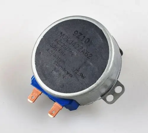 Elektromotor mit runder Bauform, zwei Anschlussklemmen und Metallgehäuse. Sichtbare Markierung "Remko" auf der Oberseite.