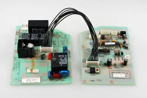 Zwei Steuerplatinen von Remko, verbunden durch Kabel, mit verschiedenen elektronischen Bauteilen wie Relais, Widerständen und Kondensatoren.