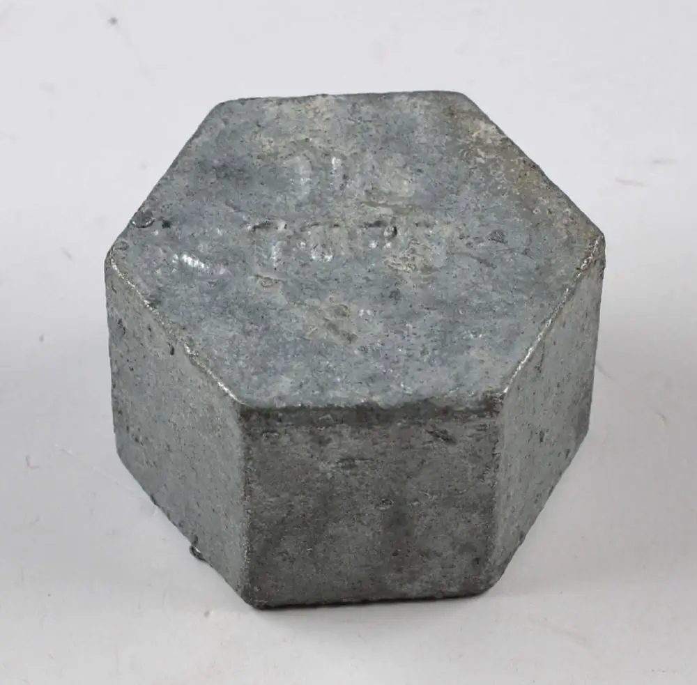 Sechseckige Metallkappe mit einer rauen Oberfläche, die für Verschlüsse bestimmt ist. Sie könnte in Verbindung mit Remko-Produkten verwendet werden.