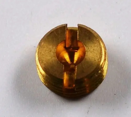 Goldfarbene Zündgasdüse von Remko mit zentralem Einschnitt und gewelltem Rand. Die Düse ist klein und präzise gefertigt.