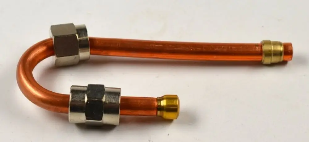 Kupferrohr mit zwei Verbindungselementen, wahrscheinlich für Gaszufuhr, gefertigt von Remko. Das Rohr hat eine gekrümmte Form und ist orangefarben.