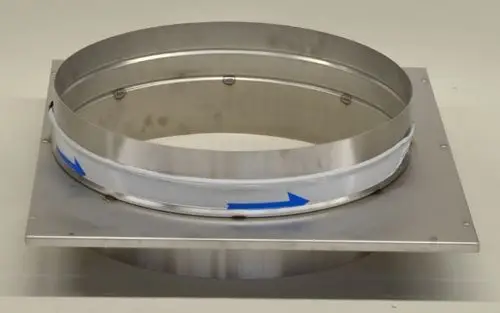 Metallischer Auslass mit runder Öffnung, montiert auf einer rechteckigen Grundplatte. An der Außenseite sind Pfeile zur Richtungsanzeige angebracht. Produkt von Remko.