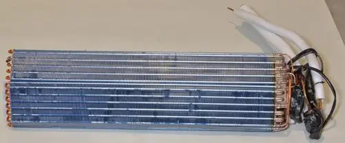Wärmetauscher von Remko, gefertigt aus Kupferrohren und Aluminiumlamellen, mit zwei Anschlussleitungen, senkrecht angeordnet.