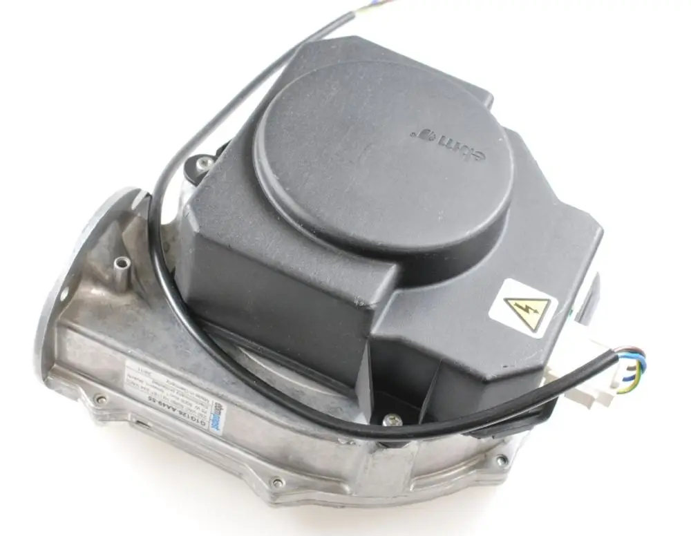 Brennergebläse von Remko, mit einem kompakten Gehäuse aus Metall und einem schwarzen Kunststoffdeckel, ausgestattet mit elektrischen Anschlüssen und einem Warnsymbol.