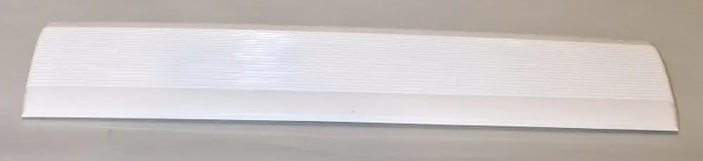 Weißes Lufteintrittsgitter von Remko auf grauem Hintergrund, mit gerillter Oberfläche für die Luftzirkulation.