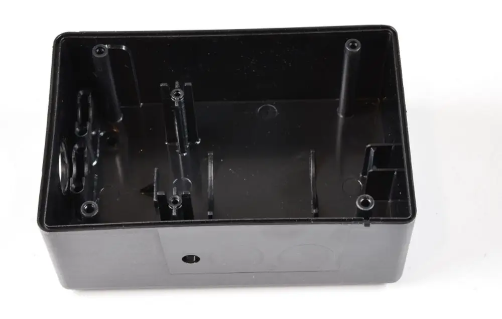 Schwarzes, rechteckiges Gehäuse mit Innenstruktur, möglicherweise aus Kunststoff. Das Produkt könnte für Thermostat-Anwendungen von Remko verwendet werden.