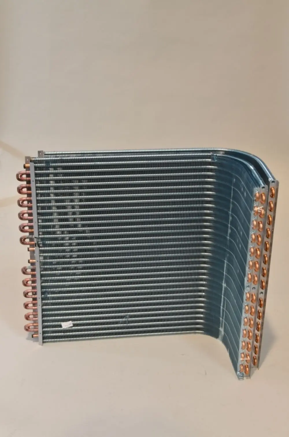 Lamellenverflüssiger mit Kupferrohren und Metallrippen, hergestellt von Remko, auf hellem Hintergrund dargestellt.