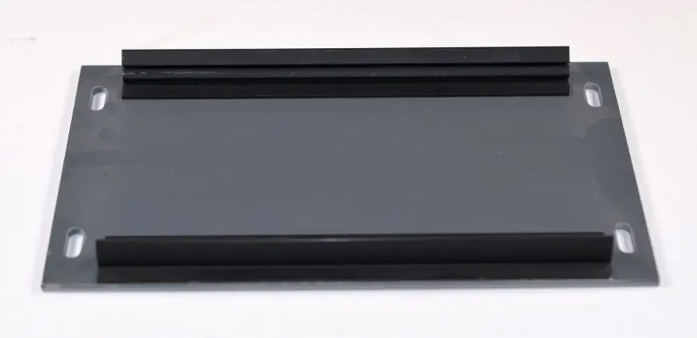 Adapterplatte mit zwei seitlichen Profilen aus schwarzem Kunststoff, montiert auf einer grauen Metallbasis, hergestellt von Remko.