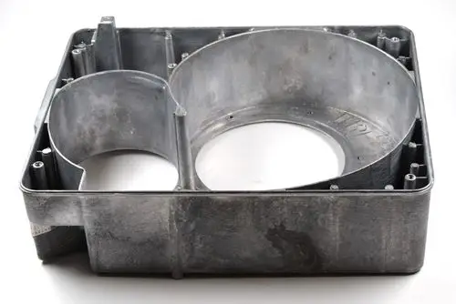 Brennergehäuse von Remko mit mehreren Öffnungen und einer Lufteinstellschraube, aus Metall gefertigt und in rechteckiger Form.