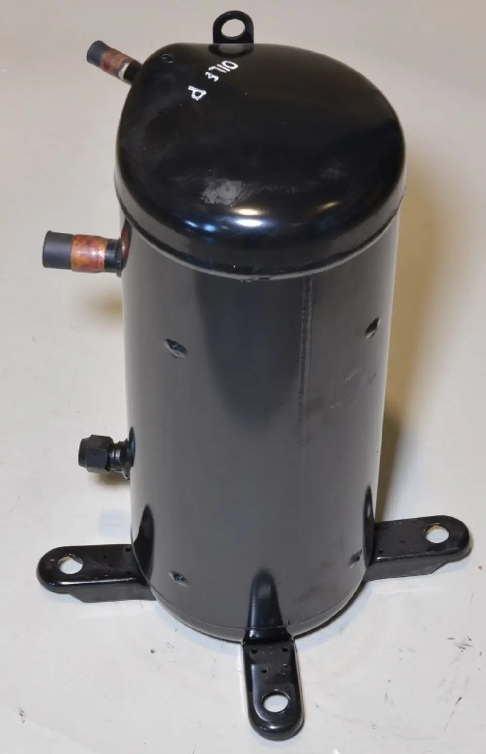 Schwarzer Kompressor von Remko mit zwei Anschlüssen und Befestigungslöchern an der Basis, auf einem neutralen Hintergrund.