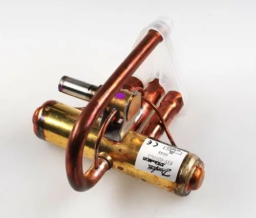 Umkehrventil aus Kupfer mit verschiedenen Anschlüssen. Das Produkt verfügt über eine klare Remko-Bezeichnung auf einem Aufkleber und ist für Heizungsanwendungen geeignet.