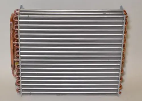 Verflüssiger von Remko mit horizontalen Metallrippen und Kupferrohren, montiert auf einer hellen Oberfläche.