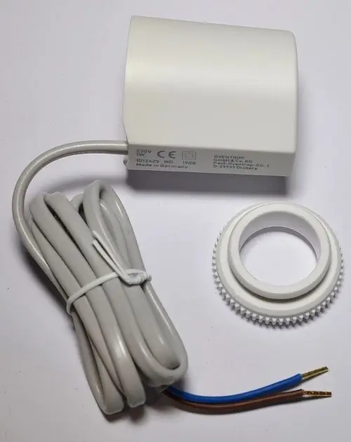 Weißer Stellantrieb mit angeschlossenem Kabel und blauen sowie braunen Drähten, ergänzt durch einen weißen Befestigungsring. Produkt von Remko.